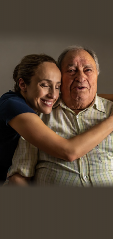 Middle-aged woman smiling and hugging an elderly man as an illustration for “Selma and Mohamed